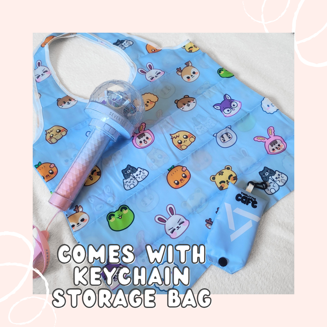 A blue tote bag with Seventeen's Miniteen characters on a white background. A 10th anniversary seventeen lightstick is on the top-left side. The tote storage clip-on bag is on the bottom-right of the image. The words "COMES WITH KEYCHAIN STORAGE BAG" in white font are at the bottom with a light-pink background.